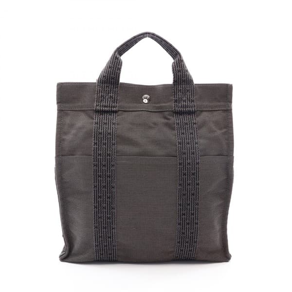 Product photograph of a grey patterned canvas backpack with a flap closure.