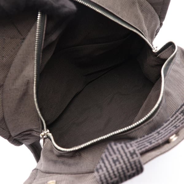 Product photograph of a grey patterned canvas backpack with a flap closure.