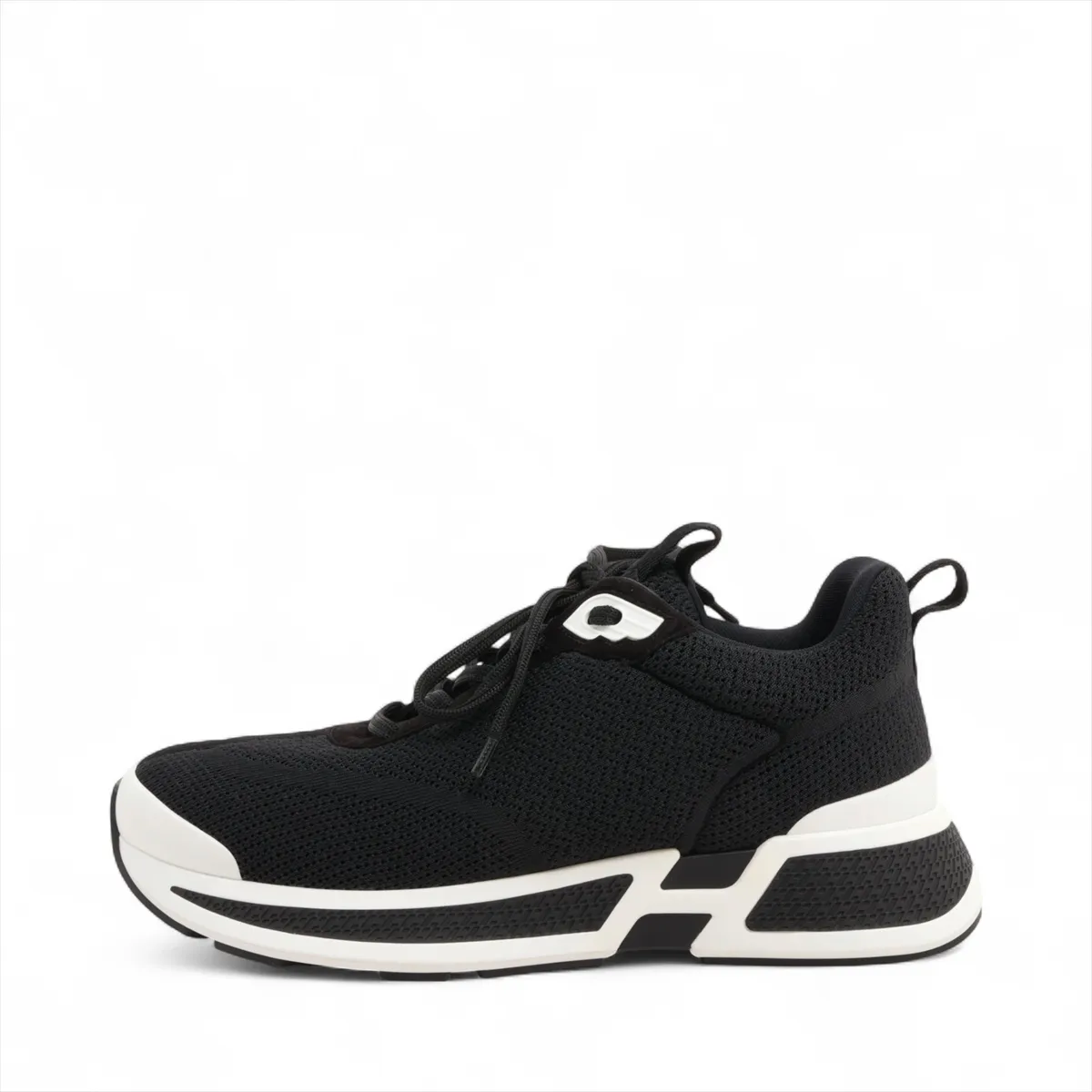 Black suede and fabric low-top sneaker with mesh inserts and a thick pale sole.