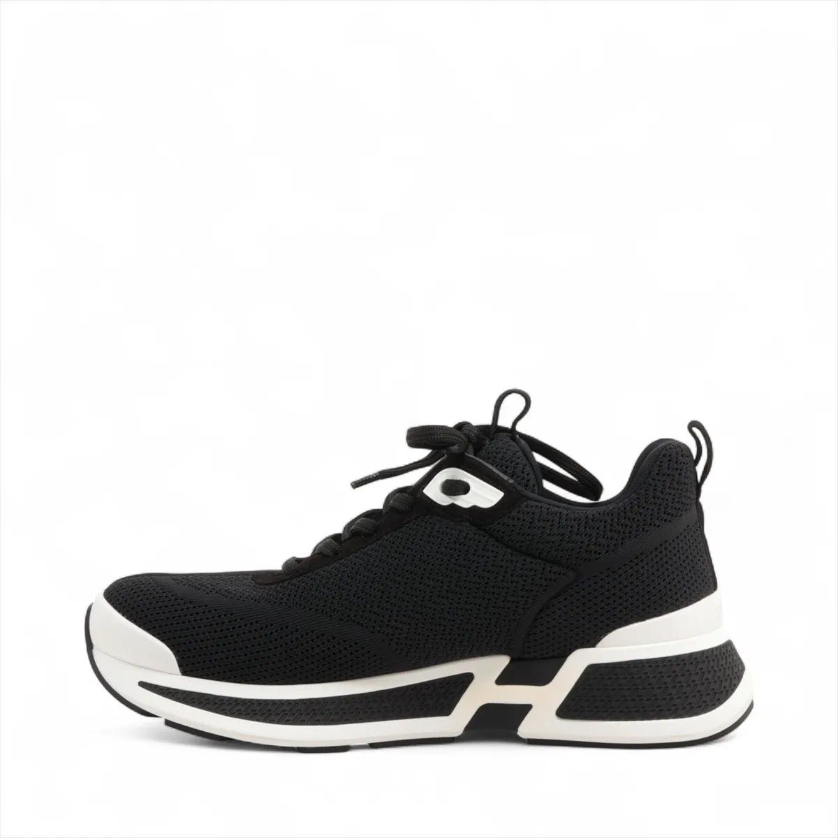 Black suede and fabric low-top sneaker with mesh inserts and a thick pale sole.