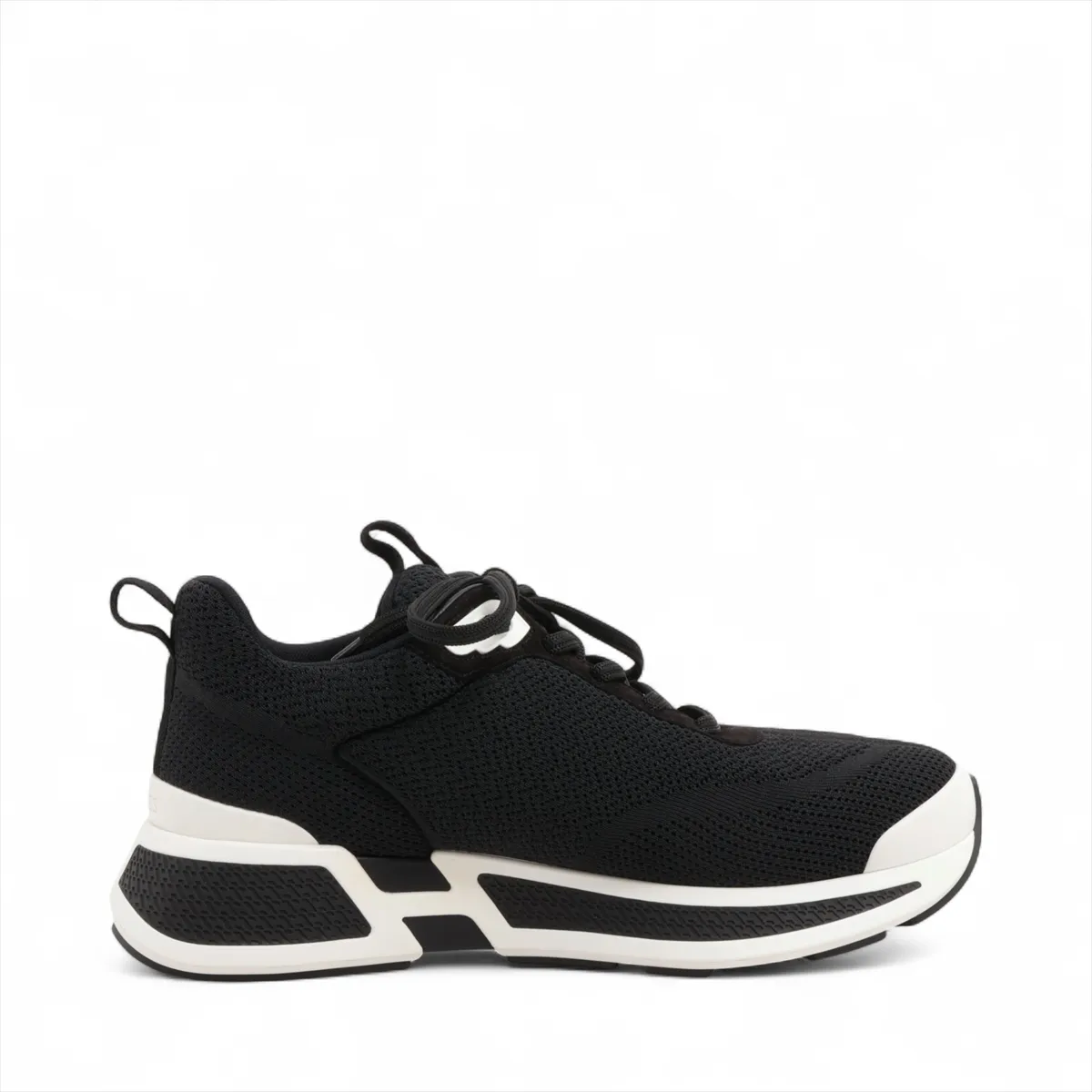 Black suede and fabric low-top sneaker with mesh inserts and a thick pale sole.