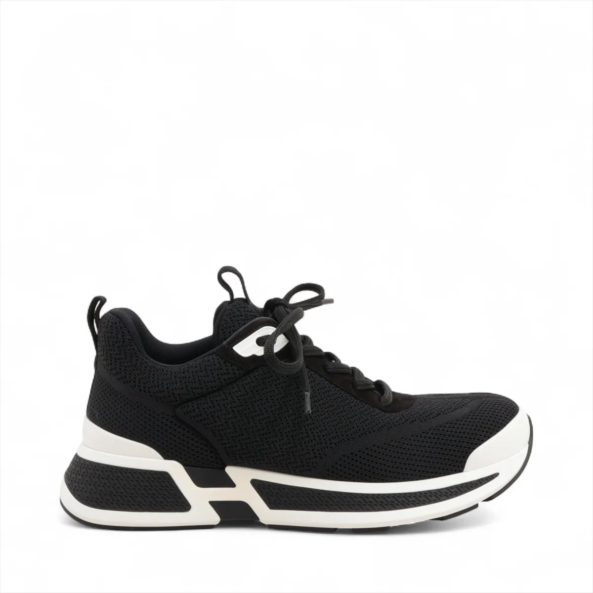 Black suede and fabric low-top sneaker with mesh inserts and a thick pale sole.