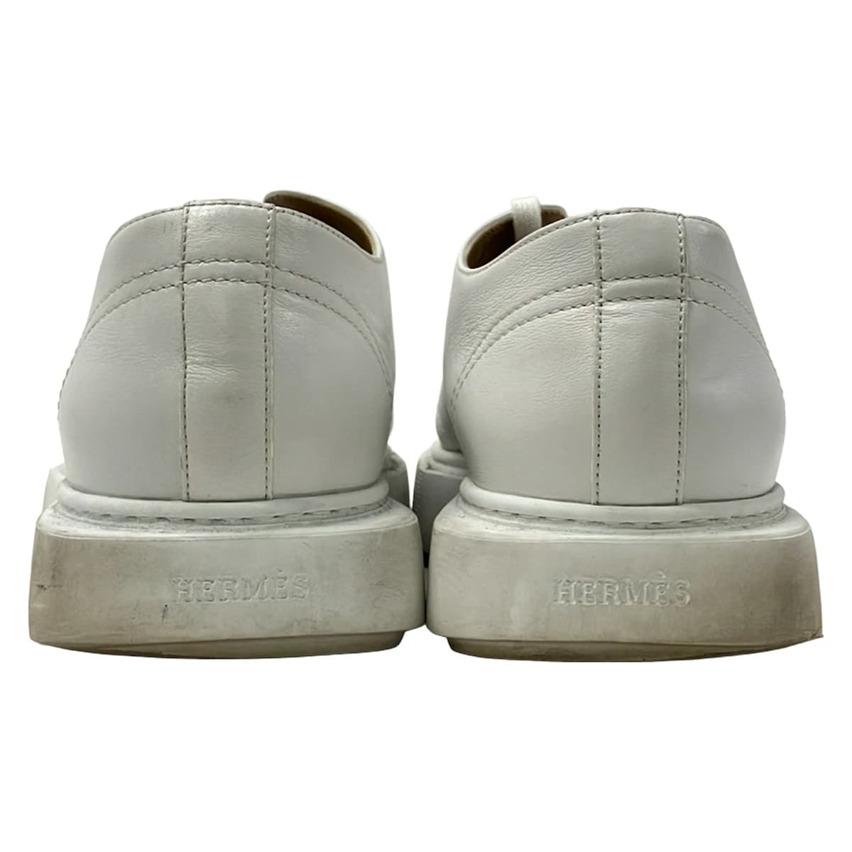White leather low-top trainers photographed from the side.