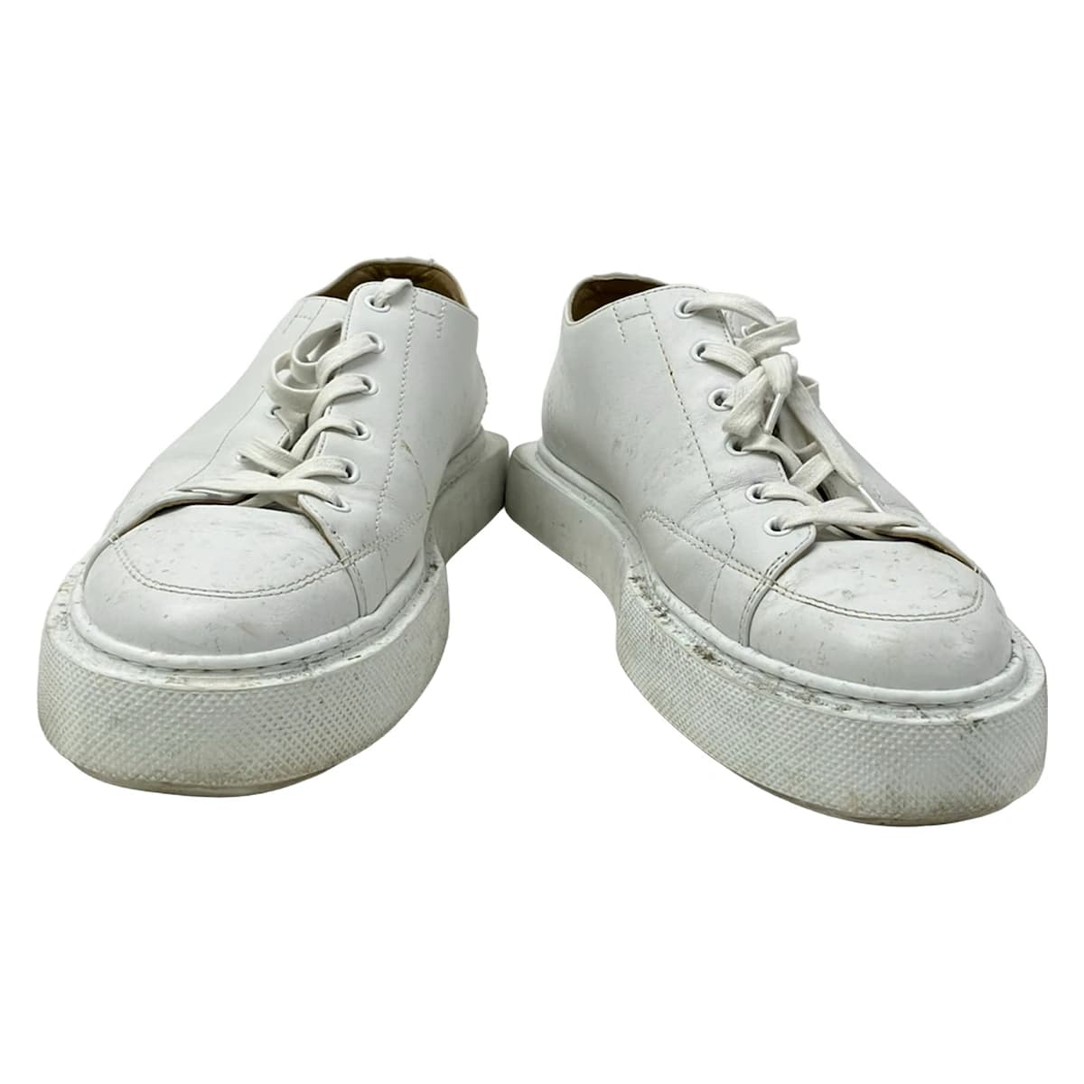 White leather low-top trainers photographed from the side.
