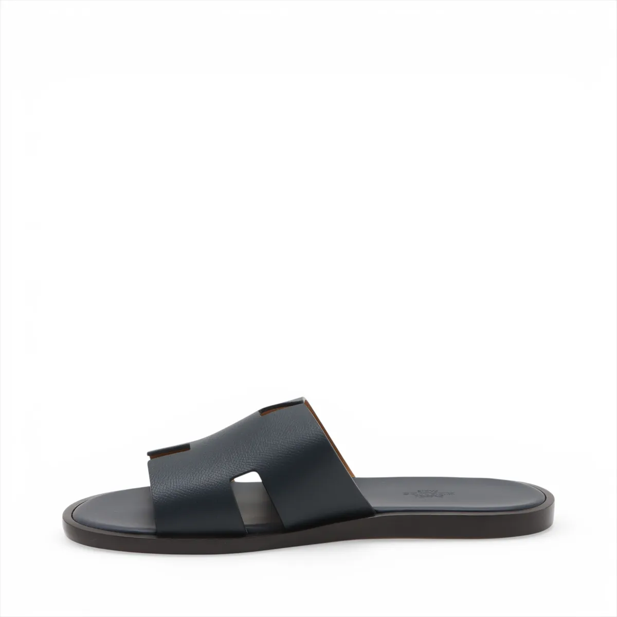 Pair of navy leather slide sandals with wide crossed straps, photographed on a plain background.
