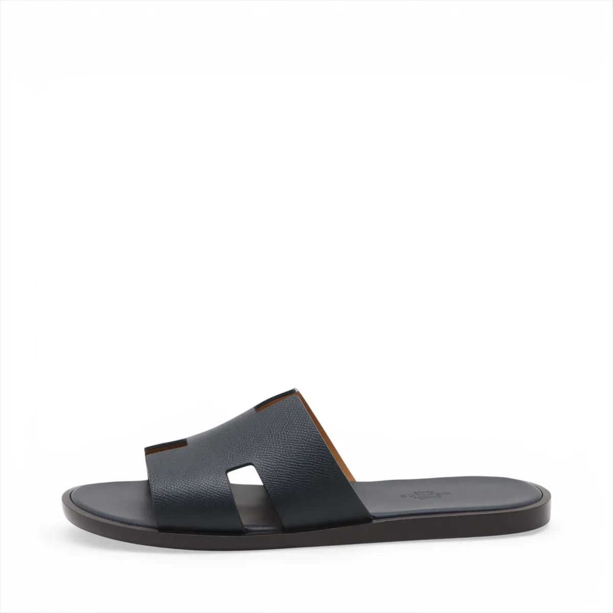 Pair of navy leather slide sandals with wide crossed straps, photographed on a plain background.