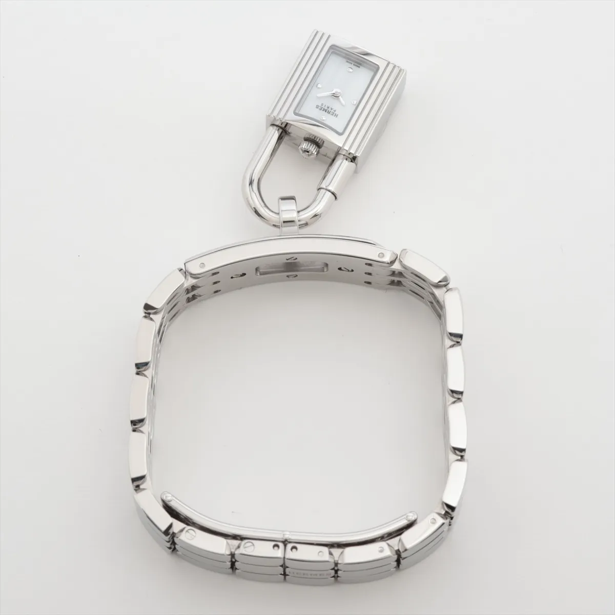 Small rectangular watch with white dial on a steel strap, shown on a plain background.