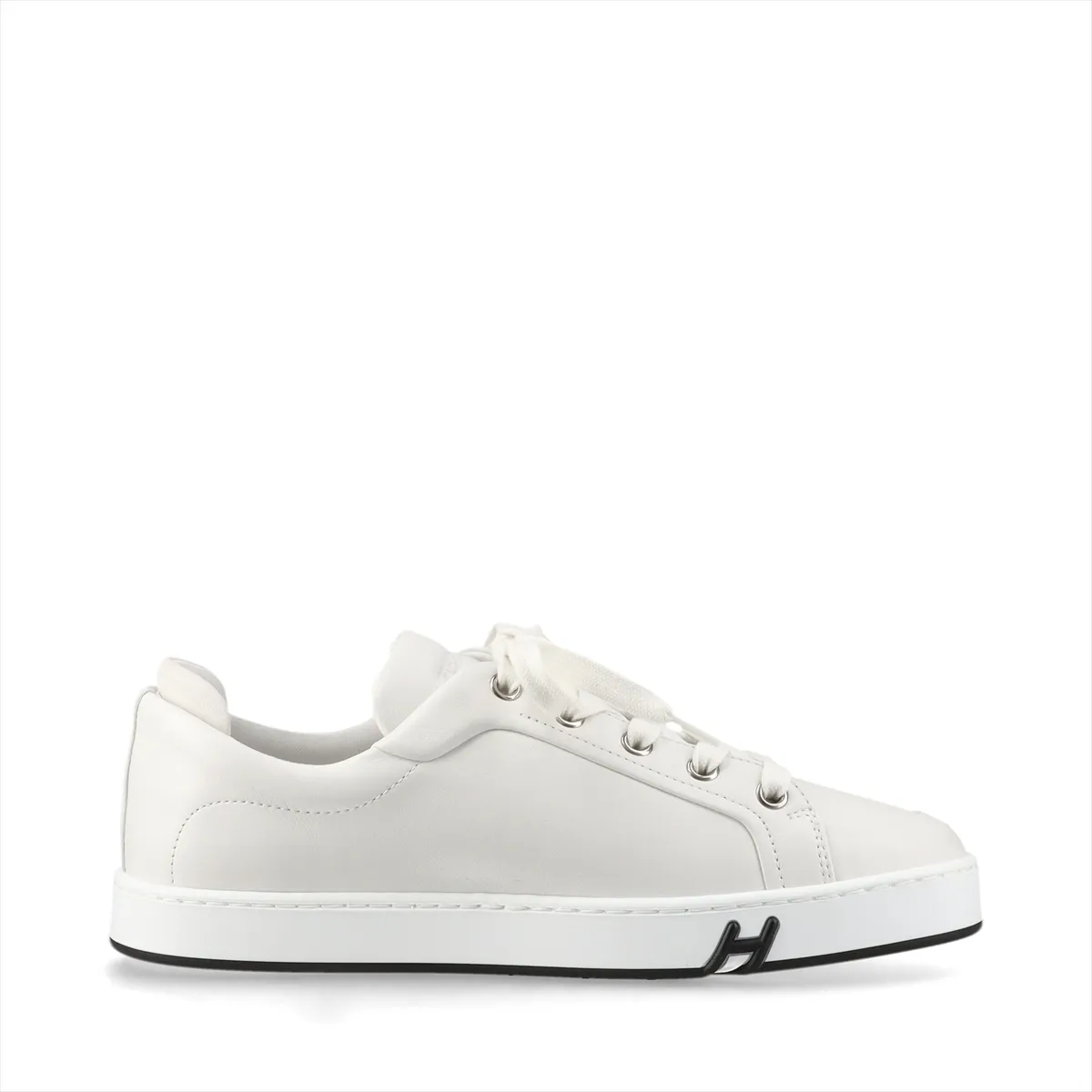 Pair of plain white leather sneakers with white soles on a neutral background