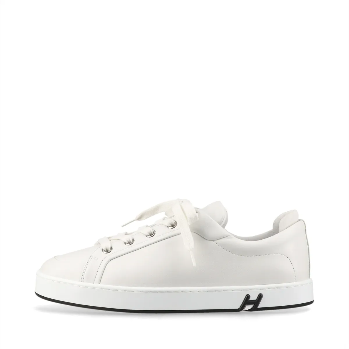 Pair of plain white leather sneakers with white soles on a neutral background