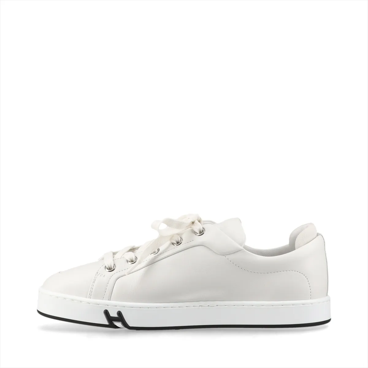 Pair of plain white leather sneakers with white soles on a neutral background