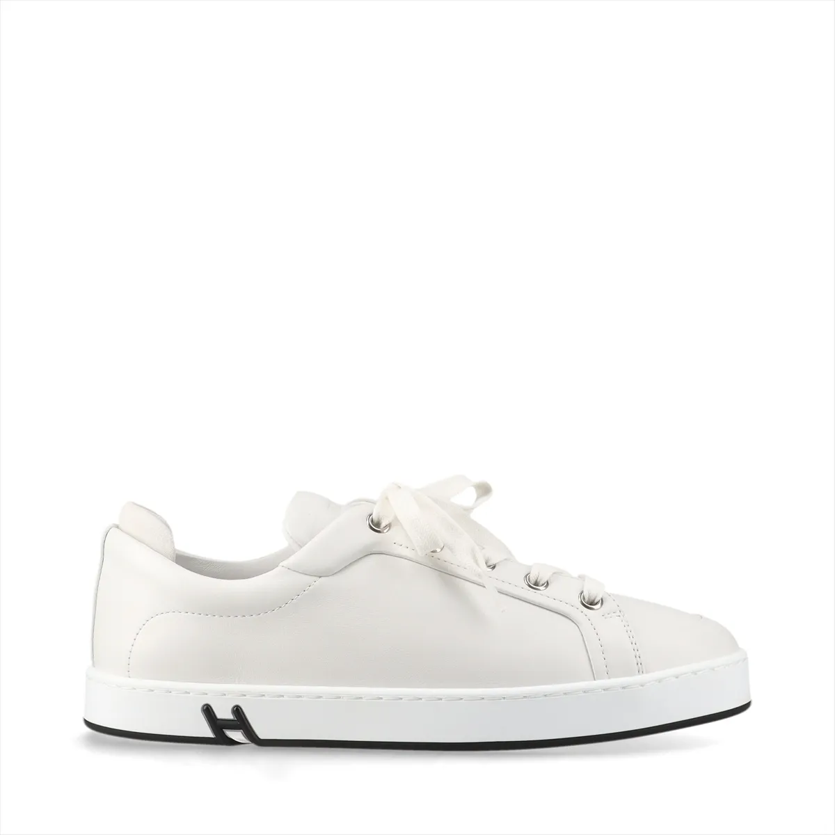Pair of plain white leather sneakers with white soles on a neutral background