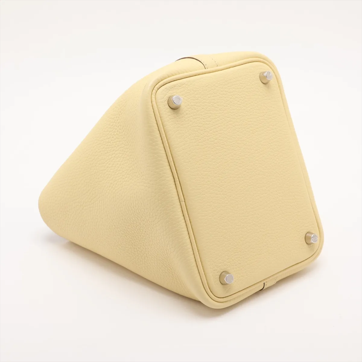 Small yellow leather bucket bag with rolled handles and silver-tone lock.