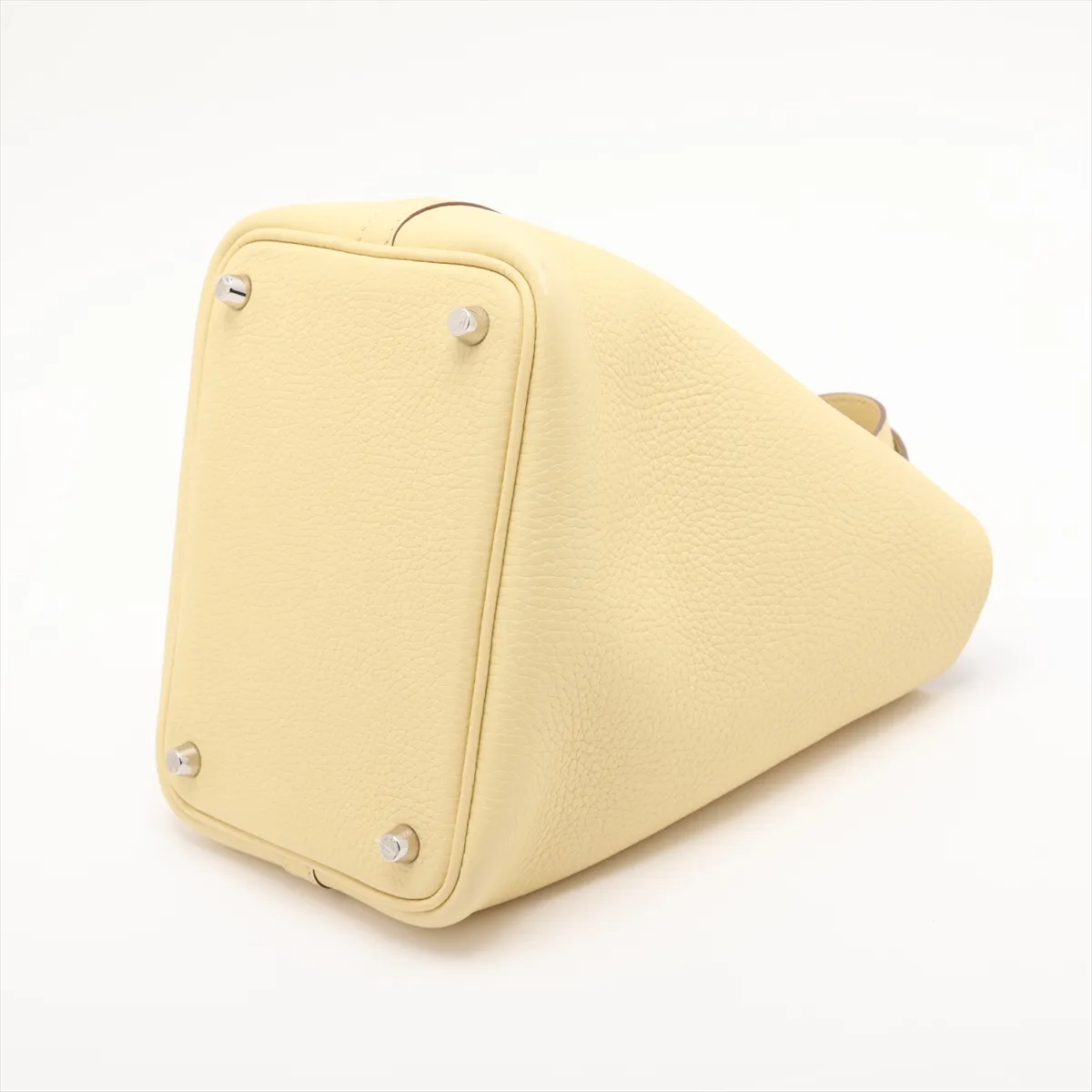 Small yellow leather bucket bag with rolled handles and silver-tone lock.