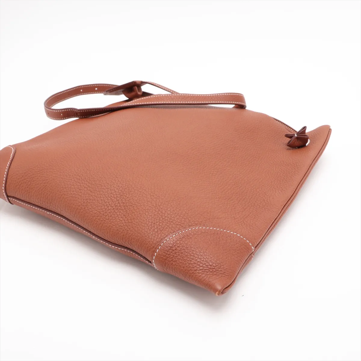 Tan leather shoulder bag with a flap front, canvas-lined body and silver hardware.