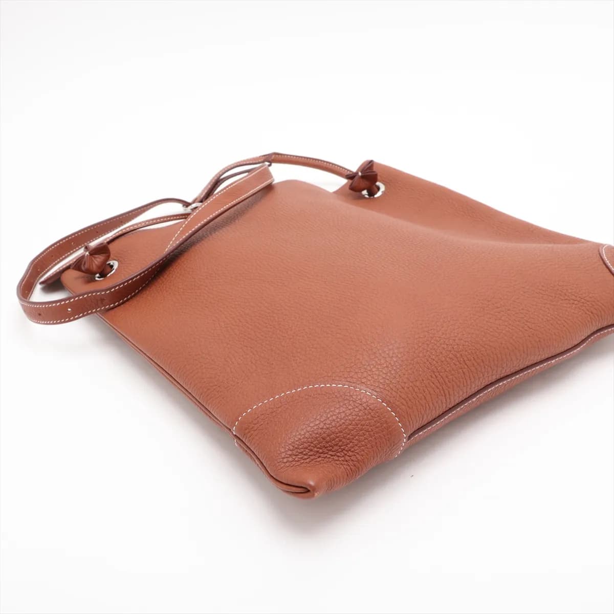 Tan leather shoulder bag with a flap front, canvas-lined body and silver hardware.