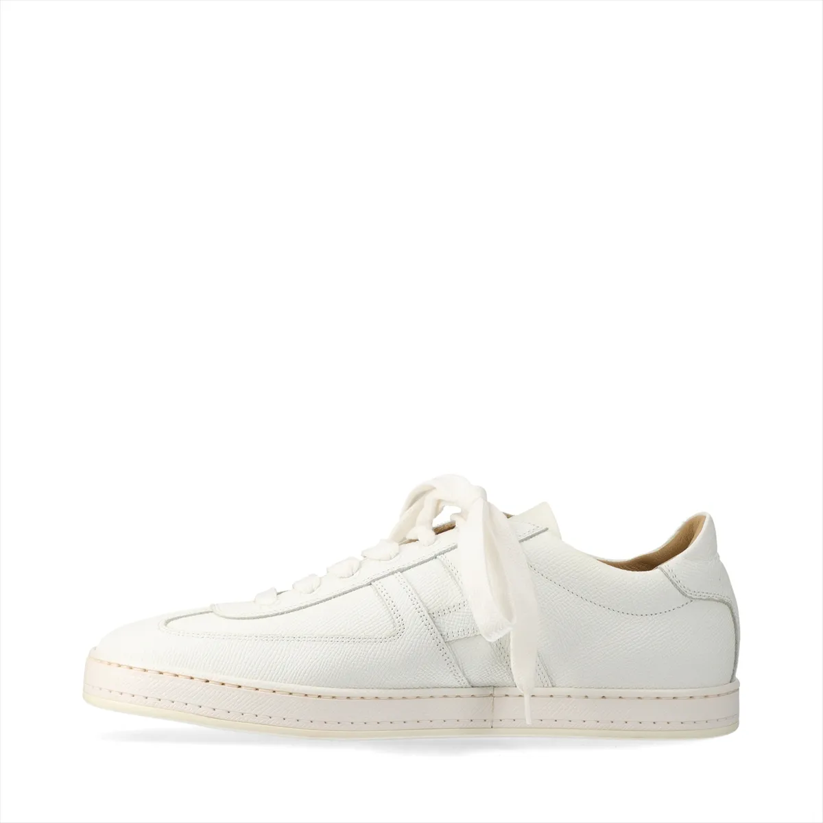 Pair of low-top white leather trainers with lace fastening, photographed on a plain background.
