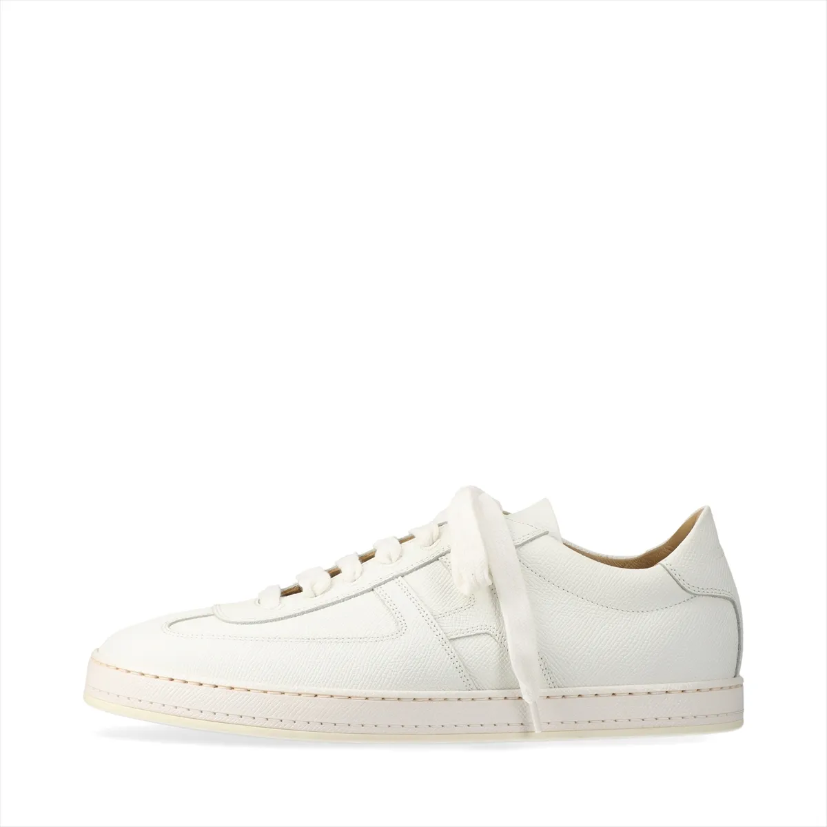Pair of low-top white leather trainers with lace fastening, photographed on a plain background.