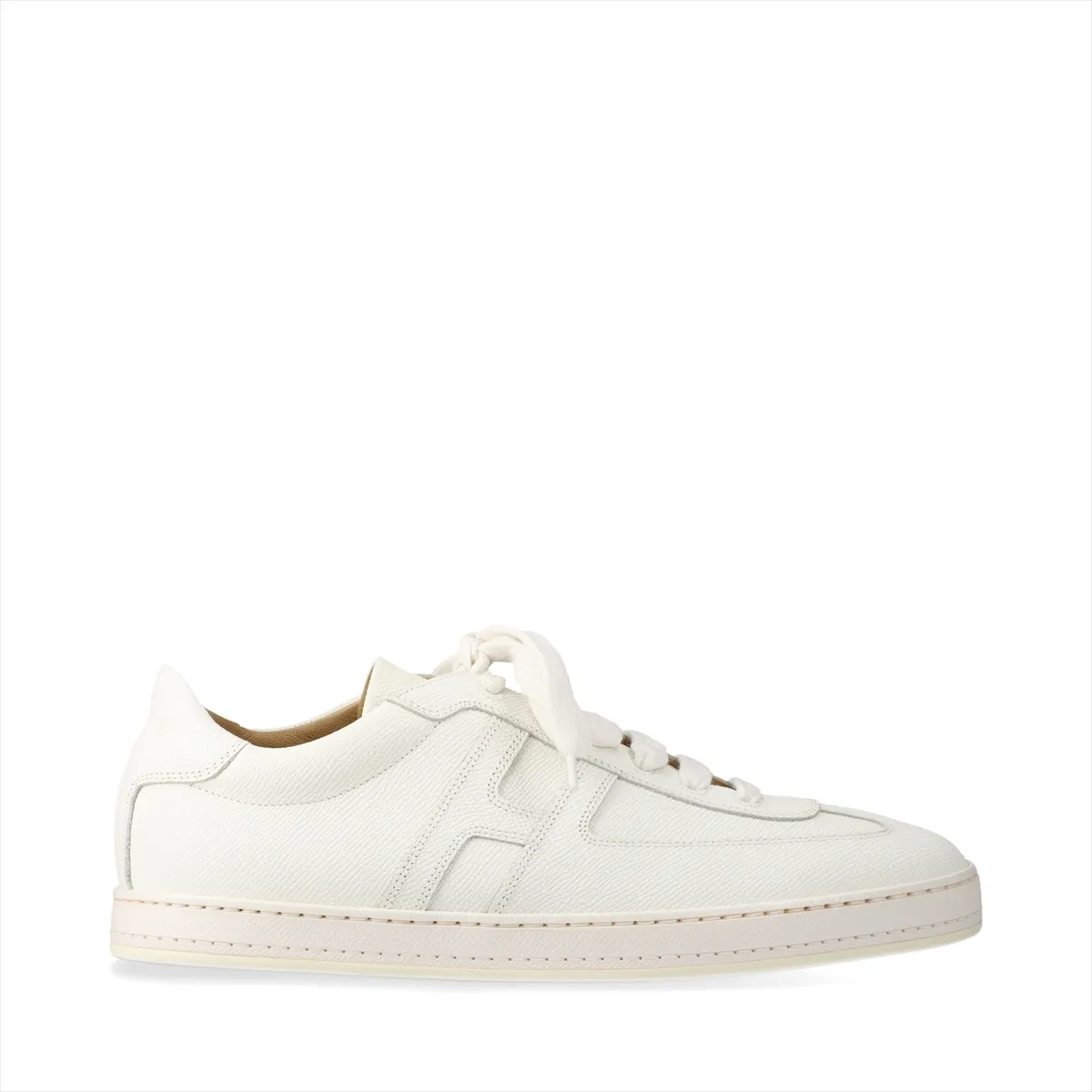 Pair of low-top white leather trainers with lace fastening, photographed on a plain background.
