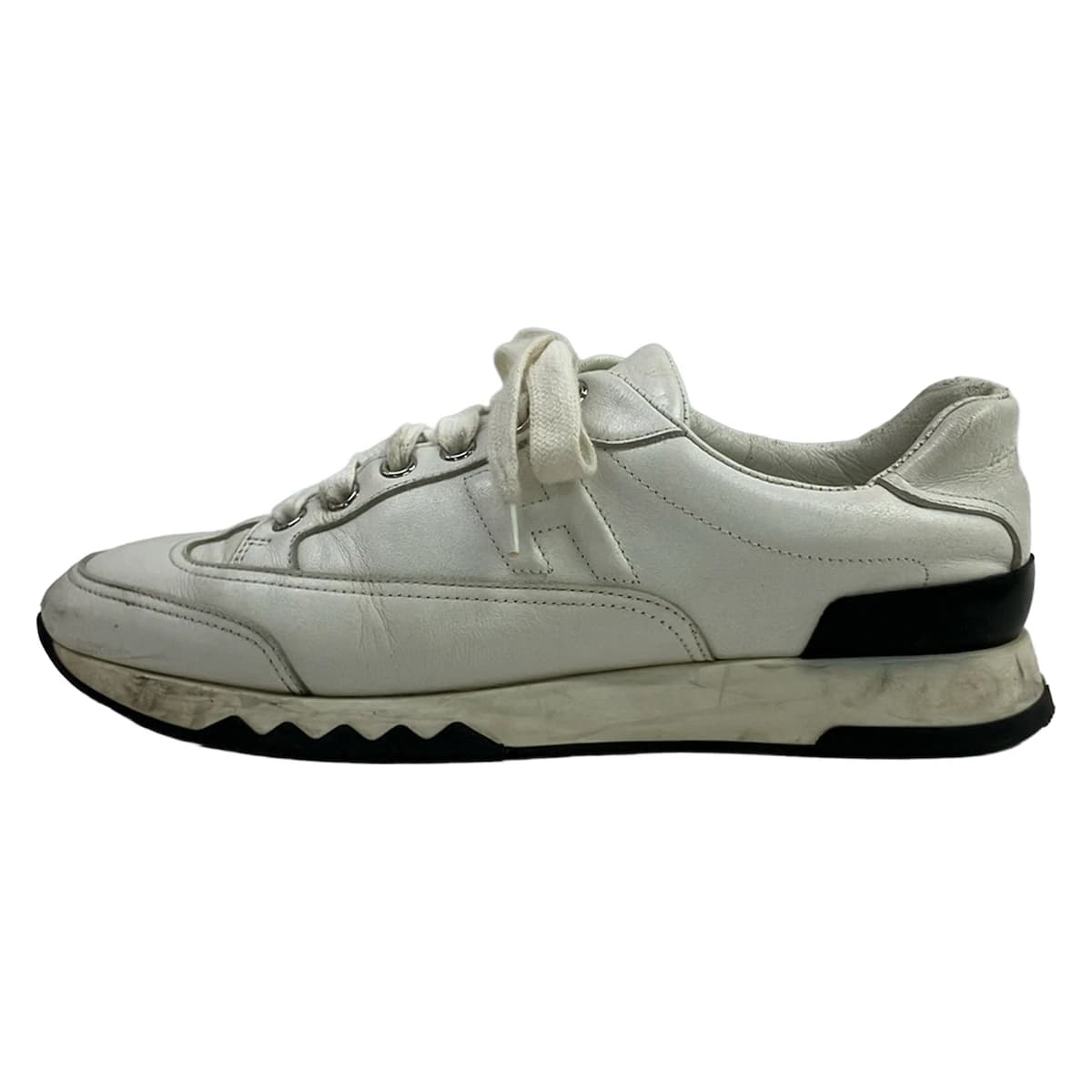 White low-top trainers with panelled uppers and chunky white soles.