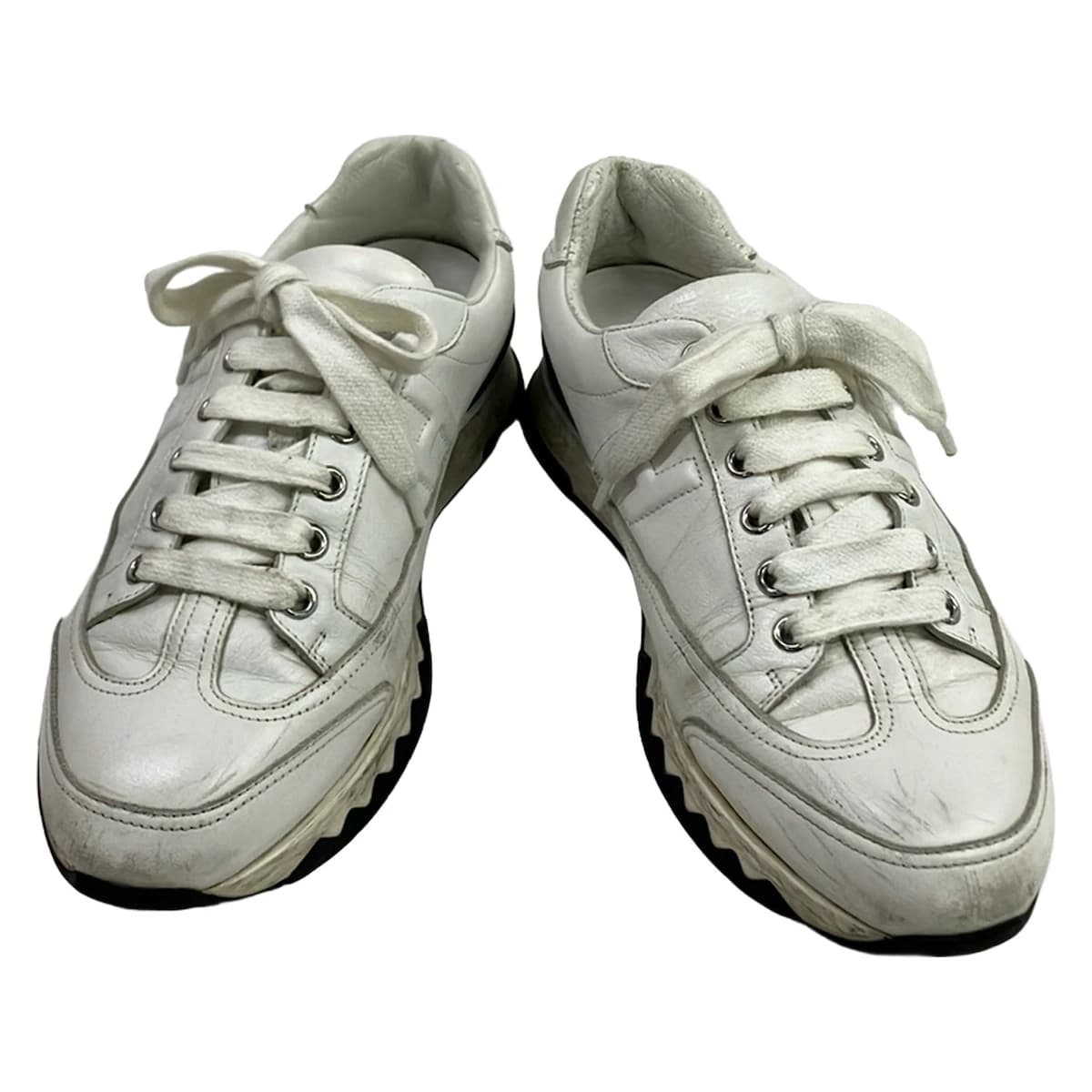 White low-top trainers with panelled uppers and chunky white soles.