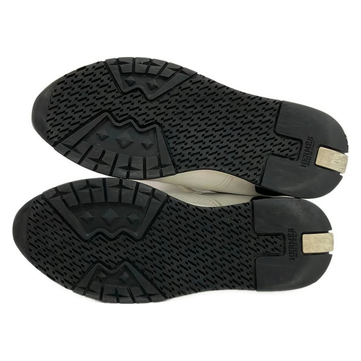 White low-top trainers with panelled uppers and chunky white soles.