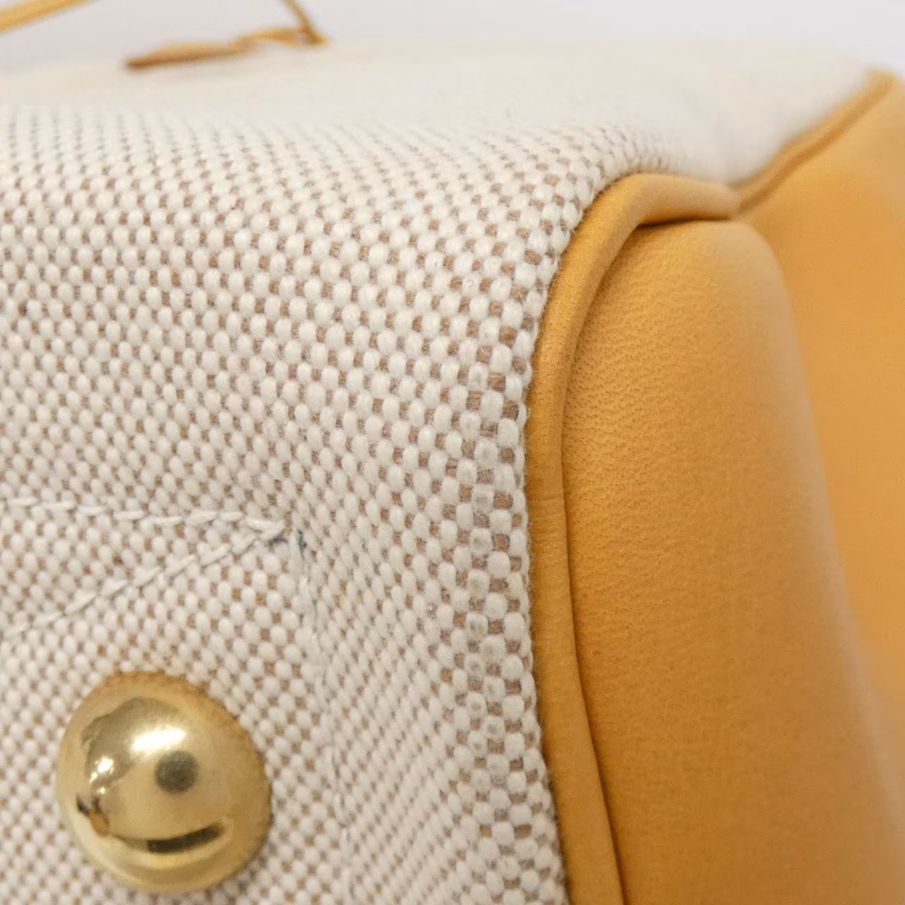Wide duffel-shaped leather travel bag with twin handles and zip top.