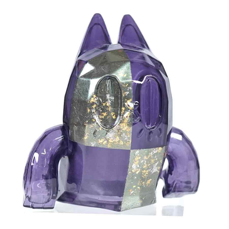 Small ghost-cat figure finished in purple checkerboard lacquer with metallic gold gradation.