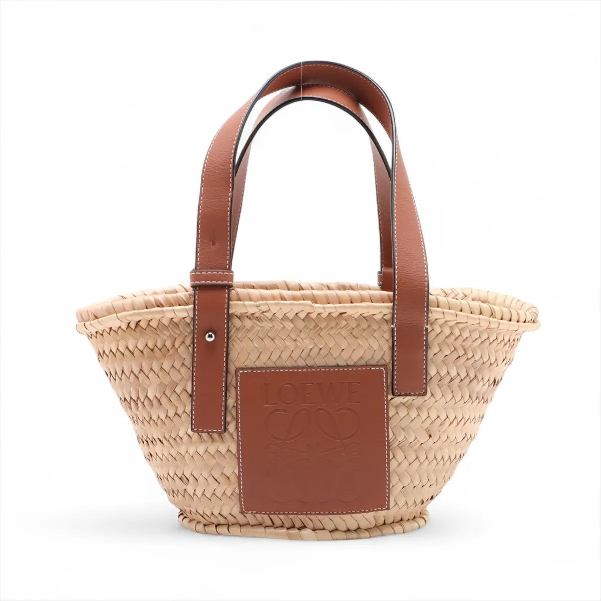 Woven natural straw basket bag with dark leather top trim and handles