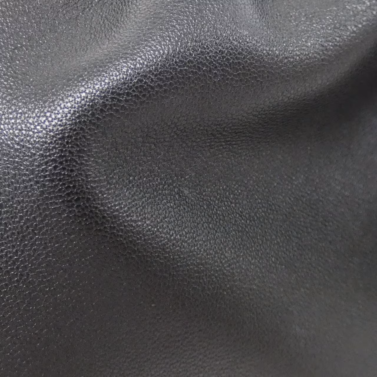 Soft leather bag with gathered sides, knotted drawstring ties and a shoulder strap