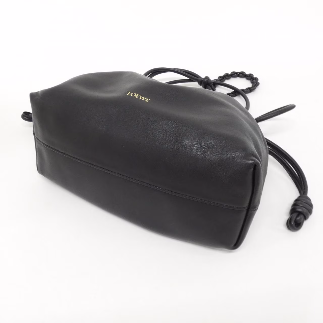 Soft leather bag with gathered sides, knotted drawstring ties and a shoulder strap