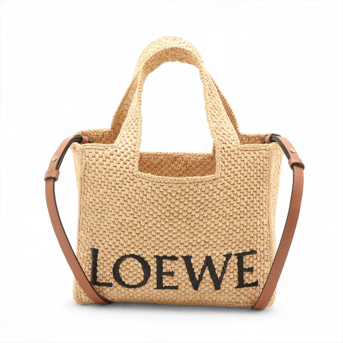 Beige woven raffia tote with leather handles and a lettered logo across the front