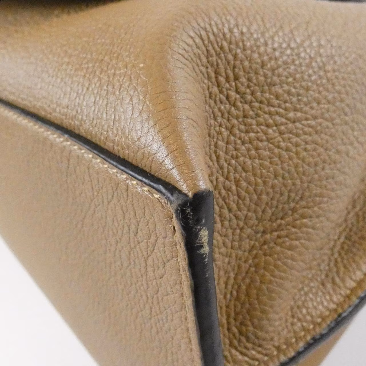 Small curved-flap bag with a top handle and knotted strap detail