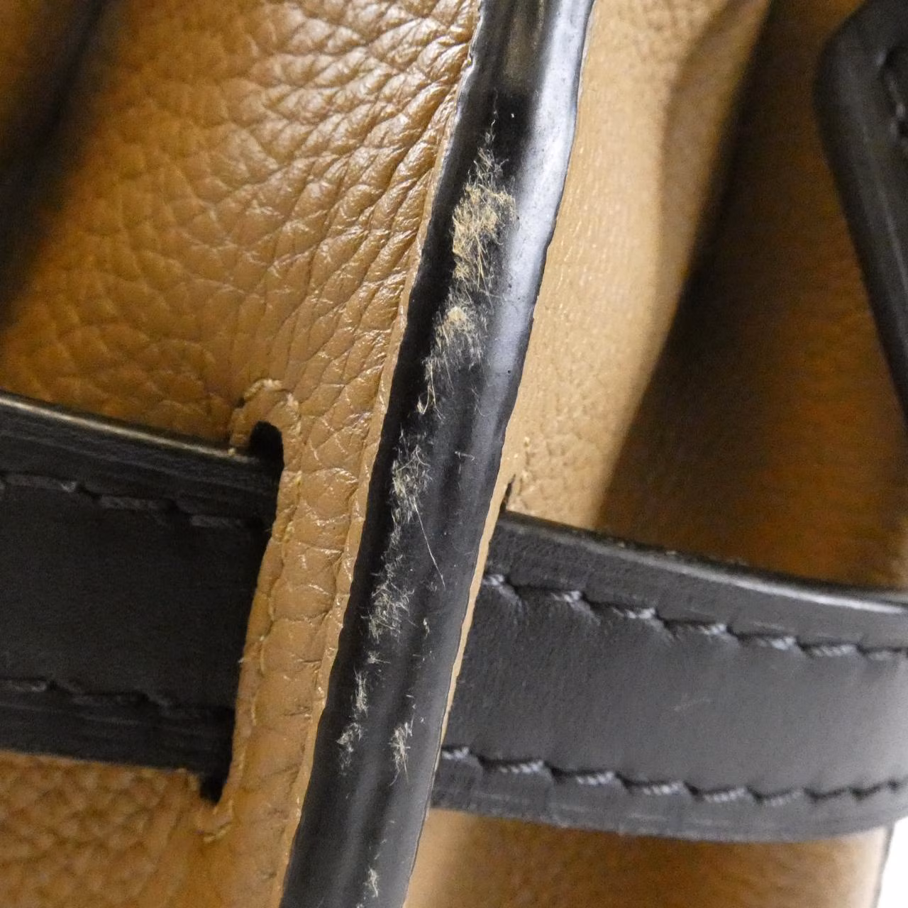 Small curved-flap bag with a top handle and knotted strap detail