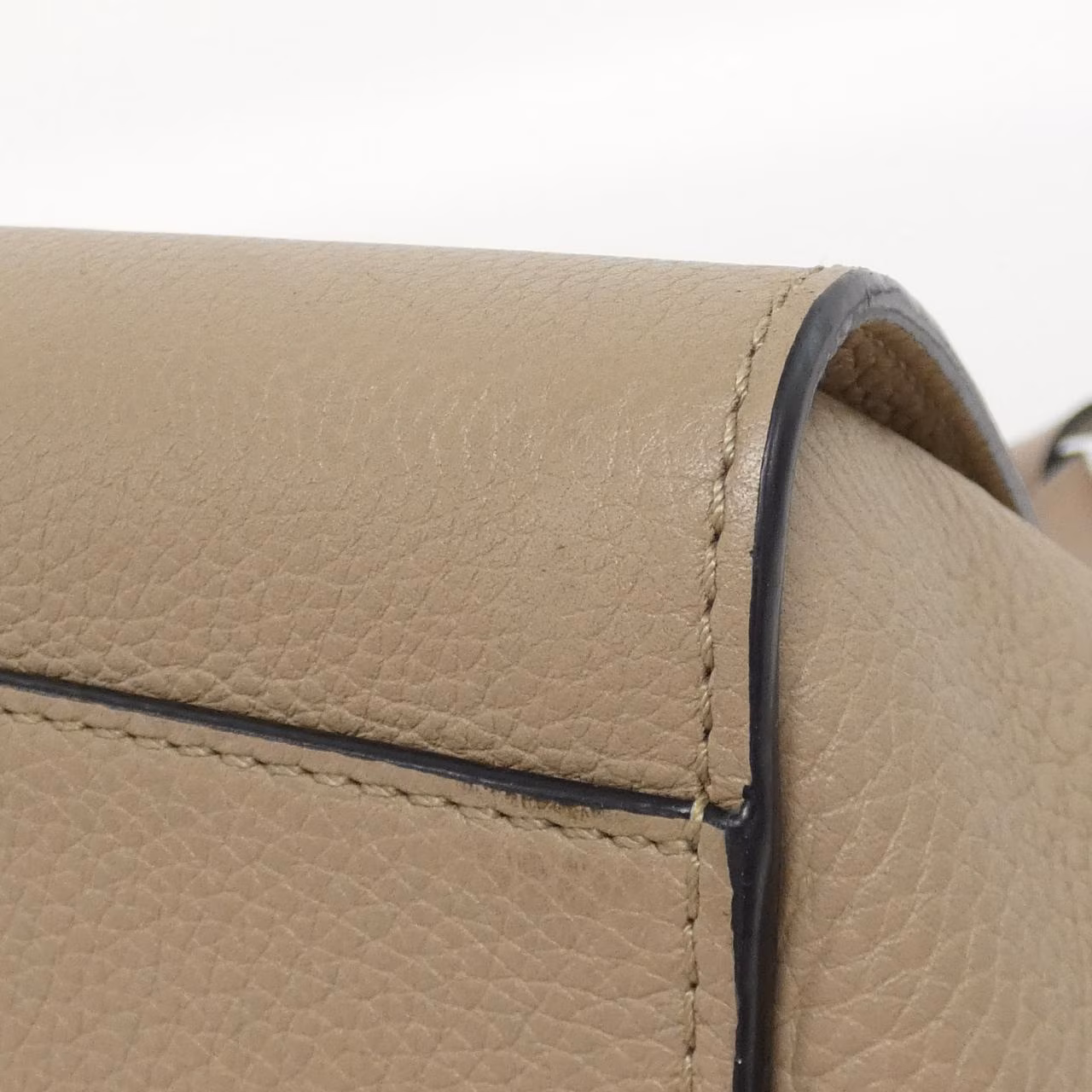 Compact leather bag with winged sides, top handle and detachable shoulder strap