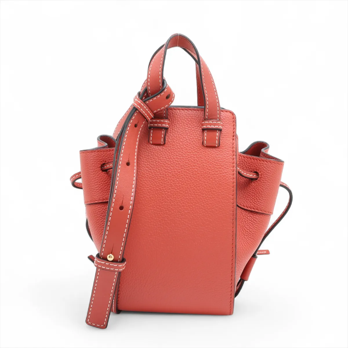 Orange leather bucket-style handbag with drawstring top and a detachable shoulder strap.