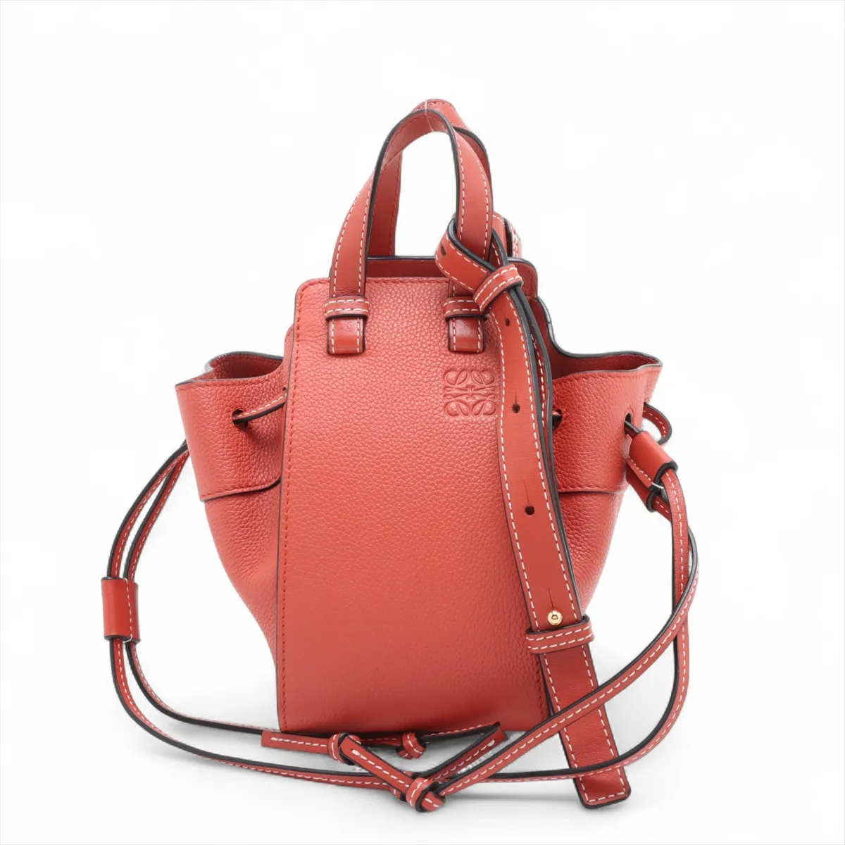 Orange leather bucket-style handbag with drawstring top and a detachable shoulder strap.