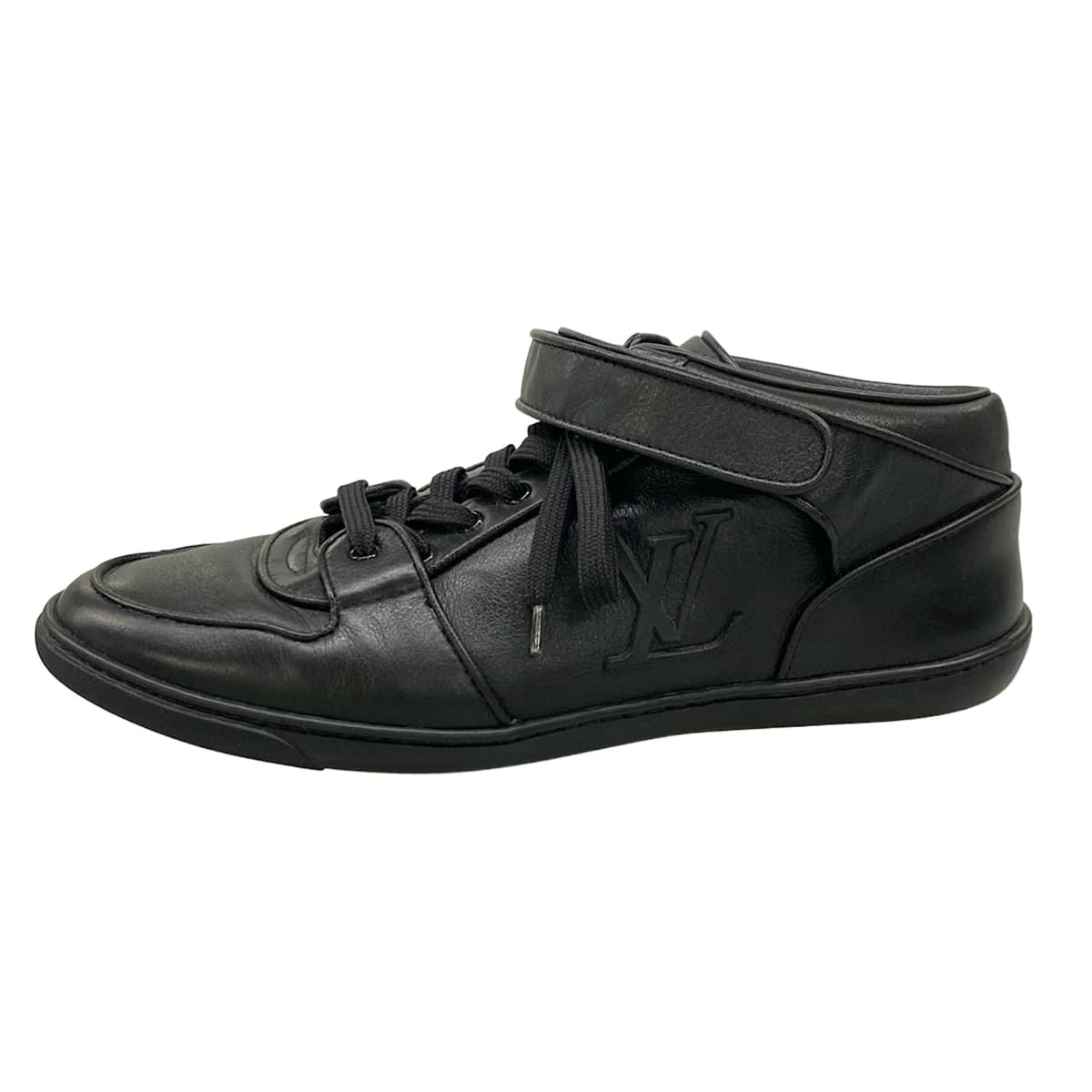 Pair of black leather low-top trainers photographed from the side.