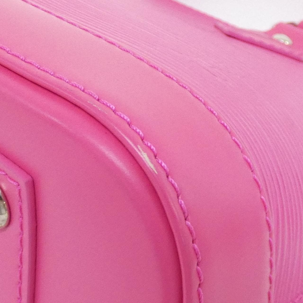 Small dome-shaped handbag in textured leather with short handles and a shoulder strap.