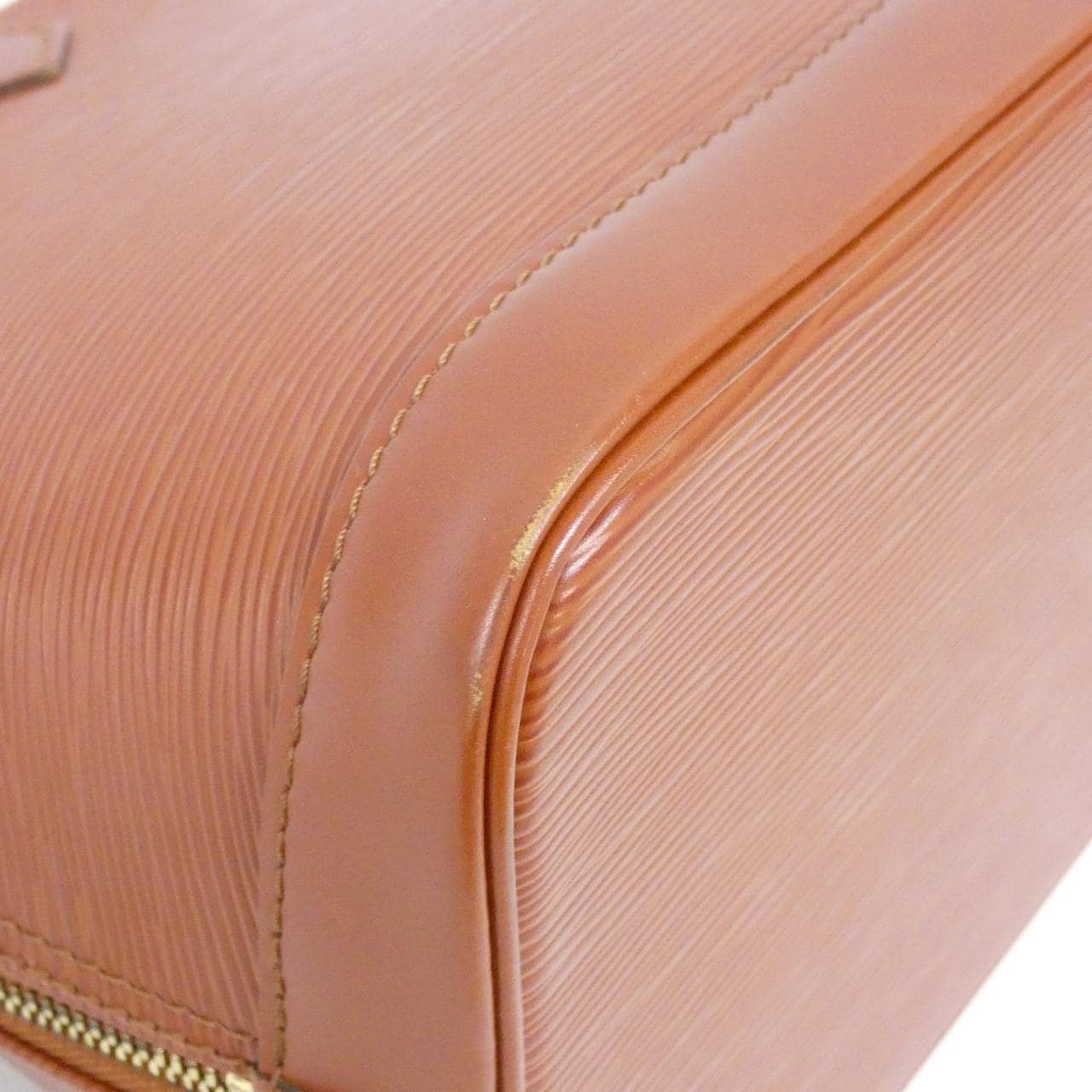 Structured dome-shaped handbag in textured leather with twin handles and a zip top.