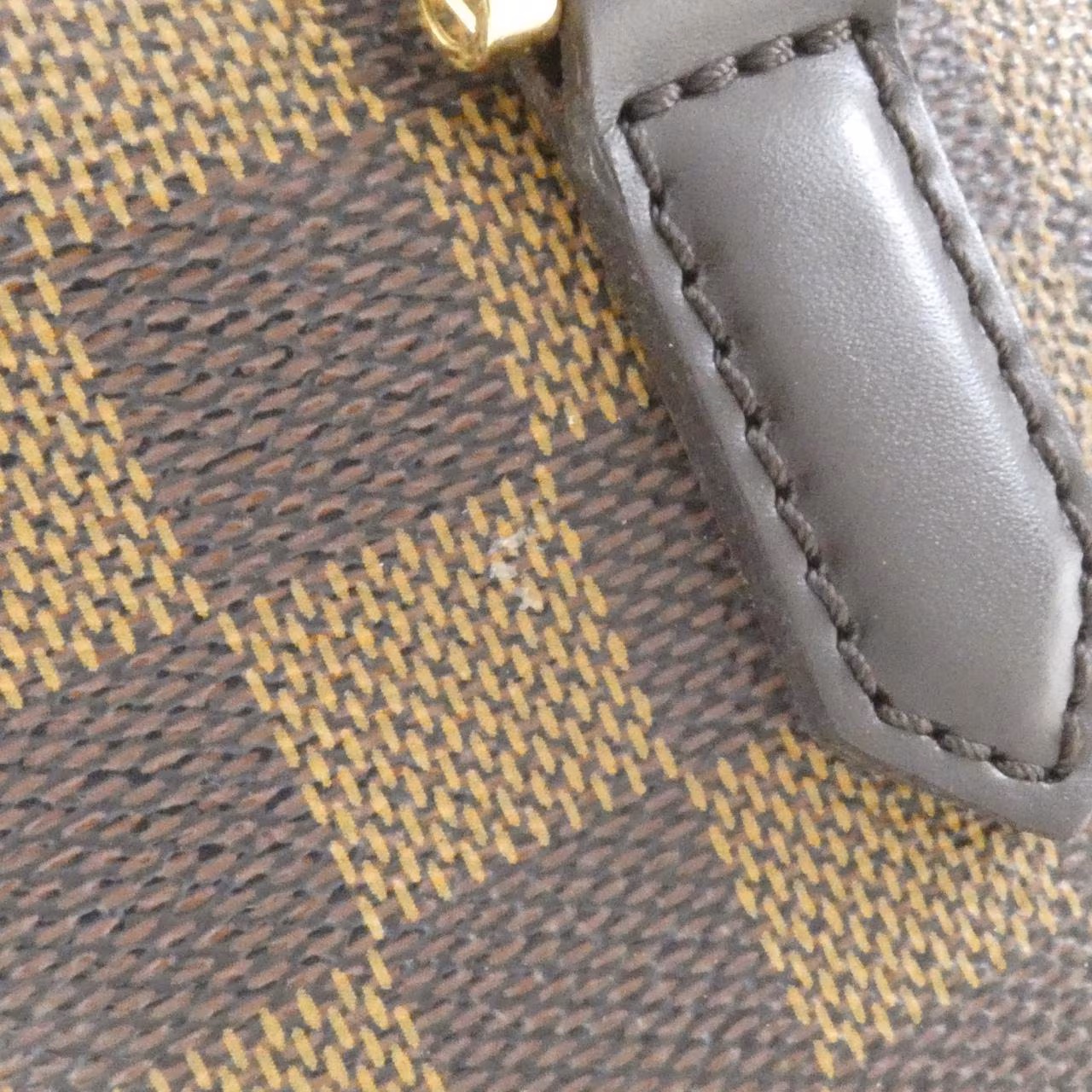 Dark brown checked canvas handbag with two short handles and a zip top.