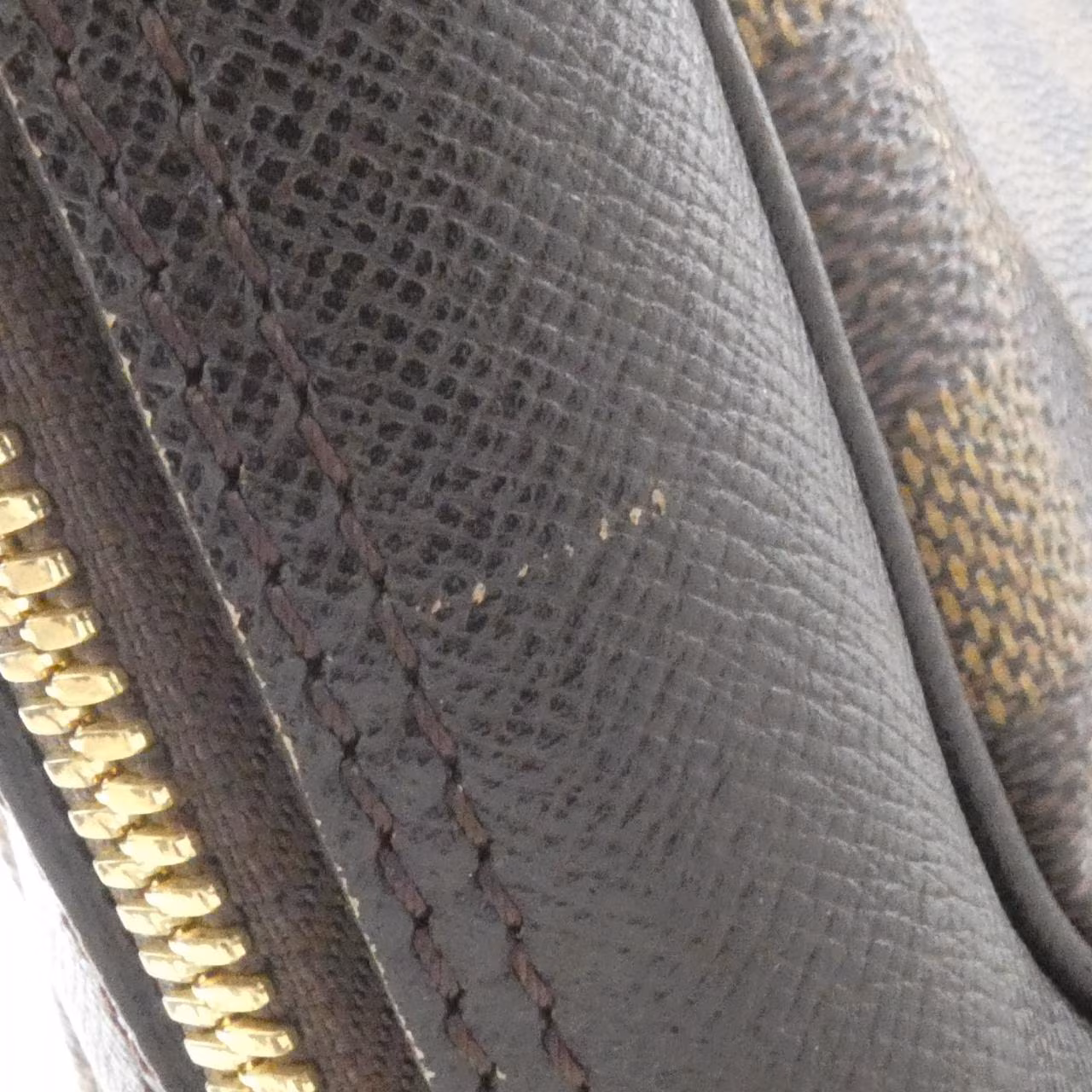 Dark brown checked canvas handbag with two short handles and a zip top.