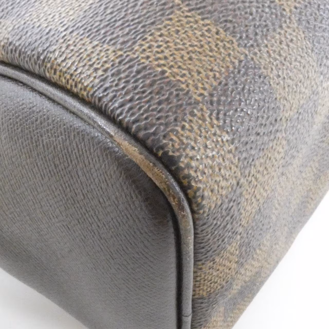 Dark brown checked canvas handbag with two short handles and a zip top.