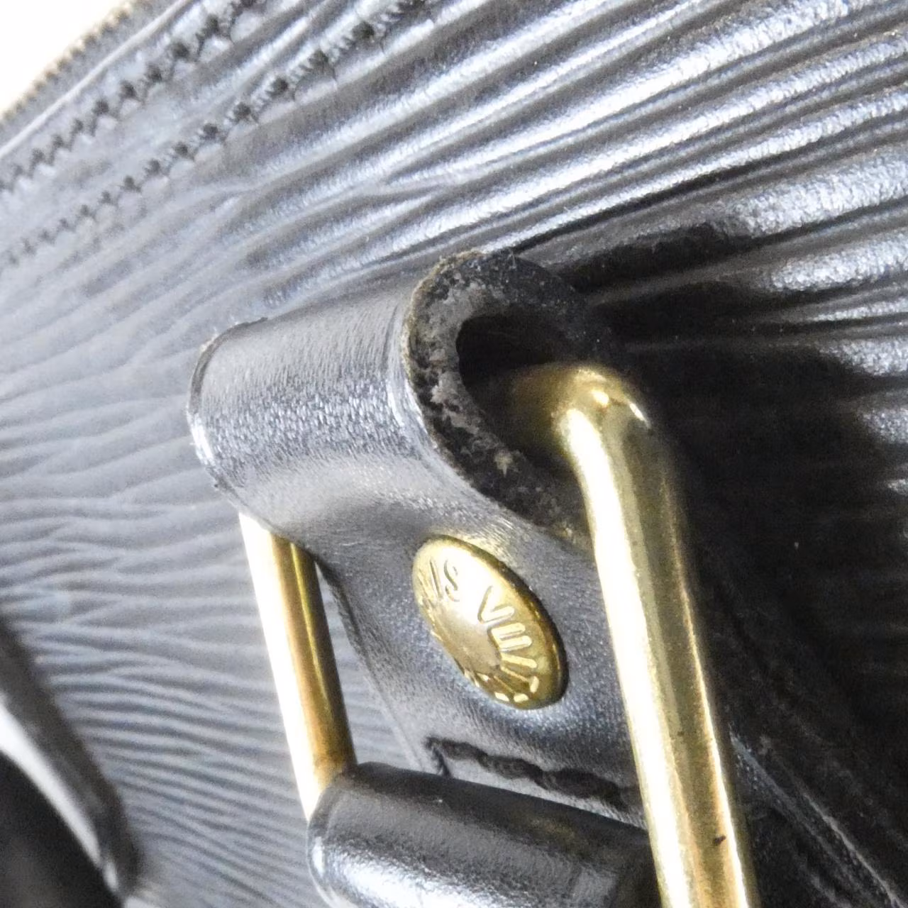 Domed textured leather handbag with rolled top handles and a curved zip opening.