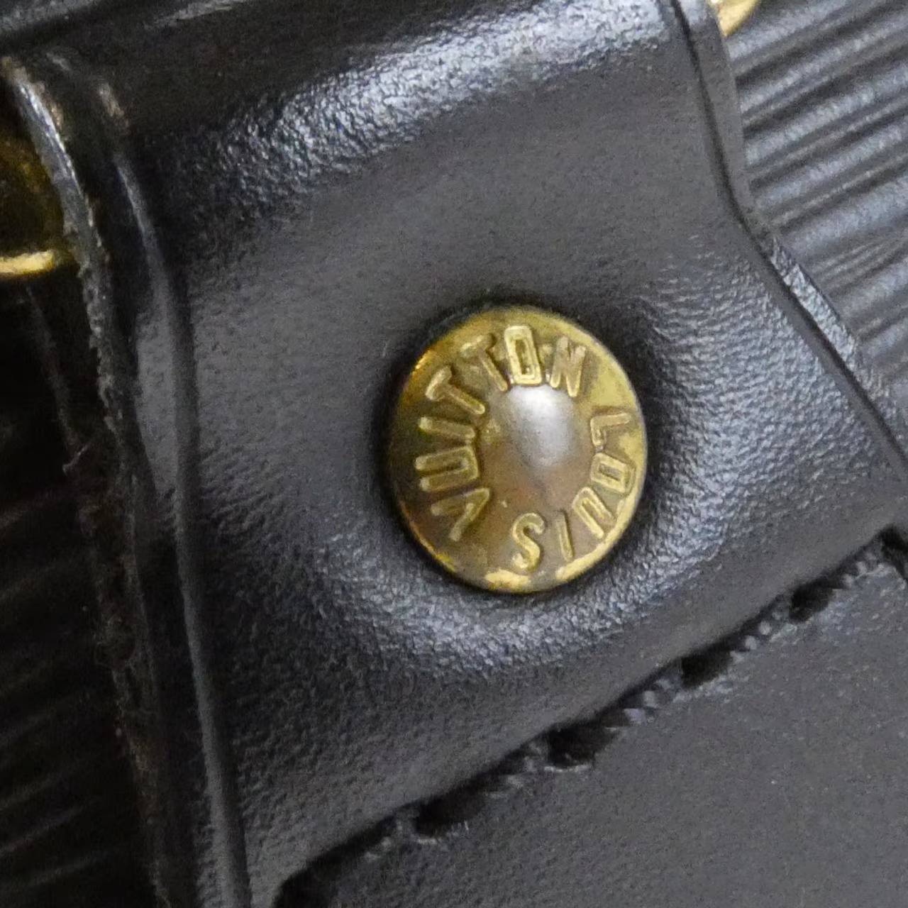Domed textured leather handbag with rolled top handles and a curved zip opening.