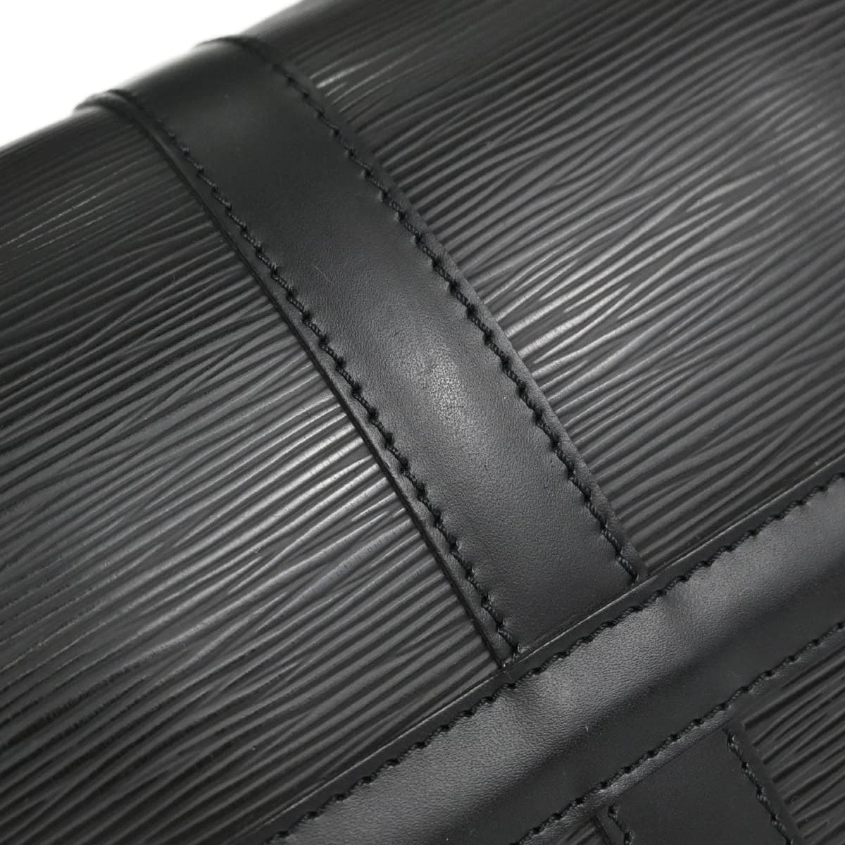 Black textured-leather duffel-style travel bag with double handles and a zip top.