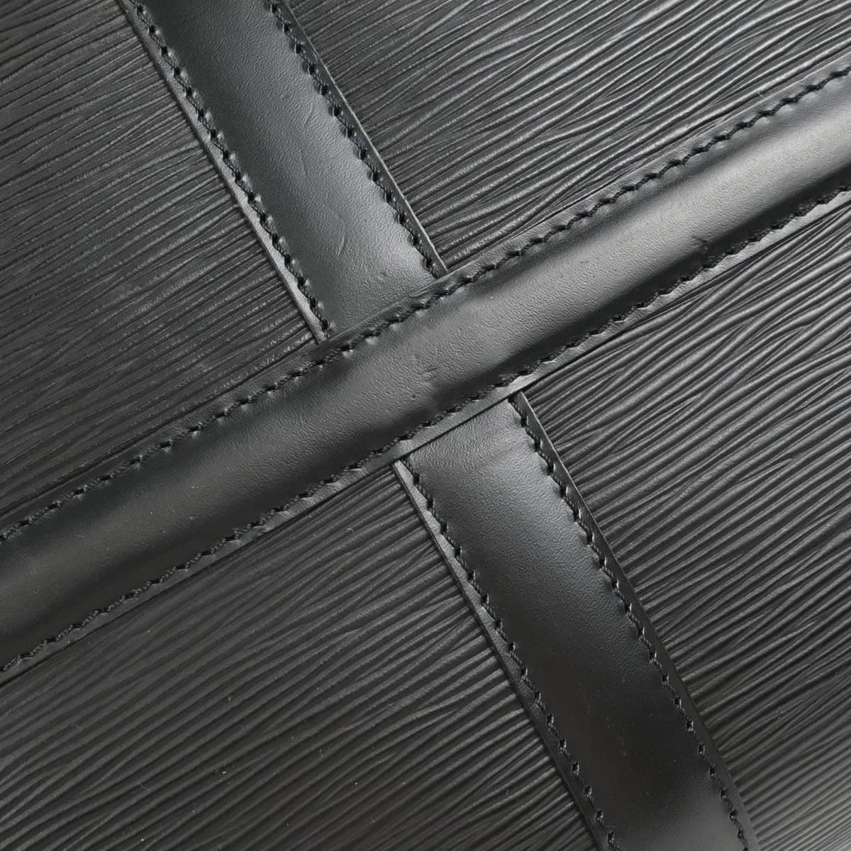 Black textured leather duffle bag with rolled handles and a zip top