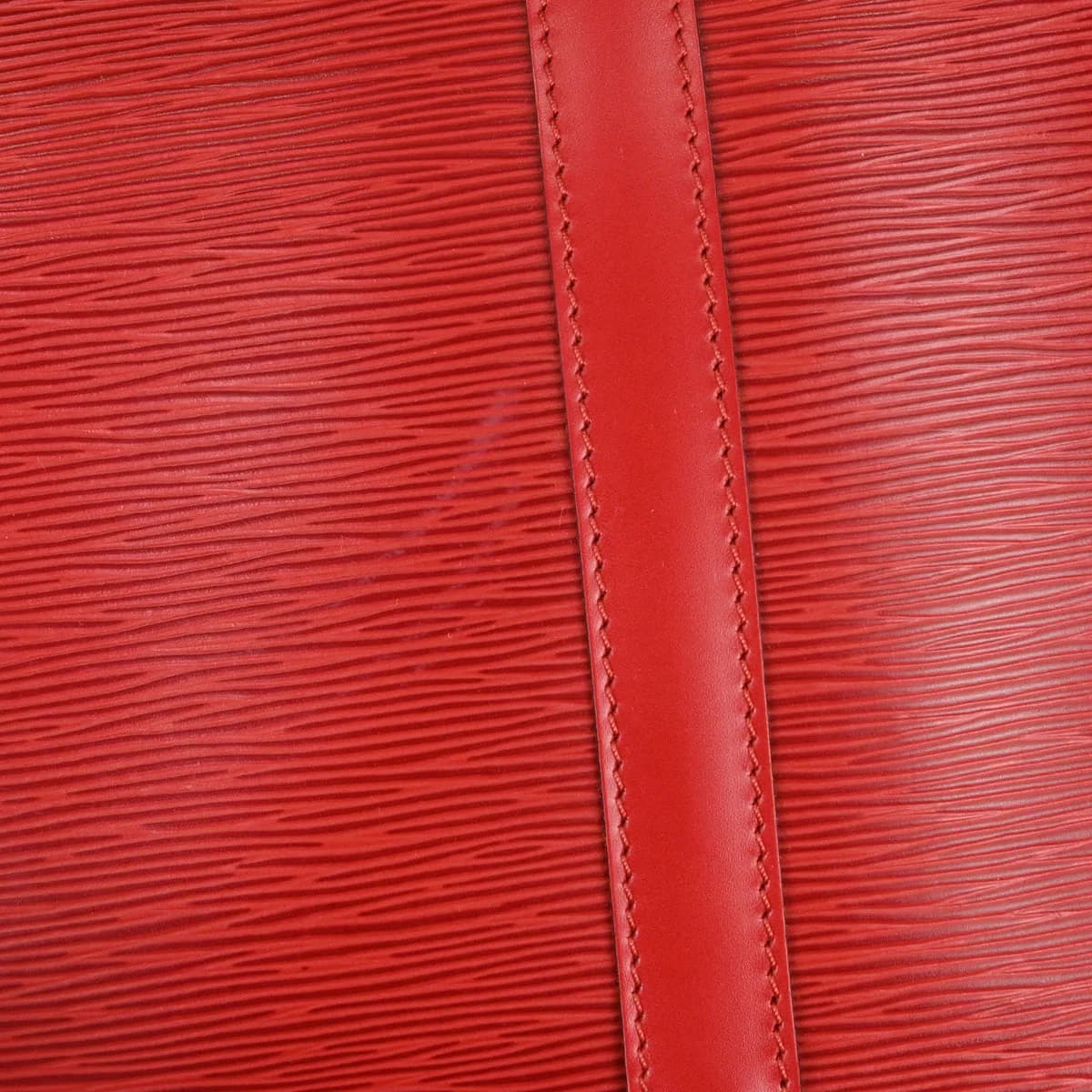 Red textured leather duffle bag with twin handles and a zip top.