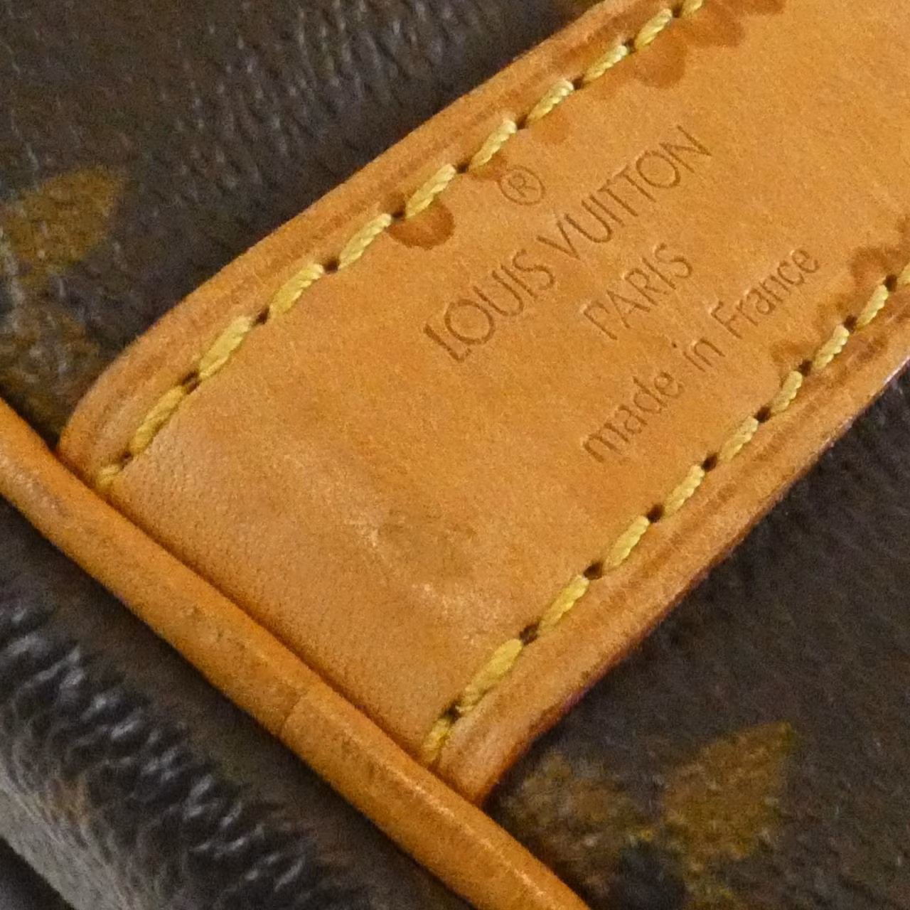 Brown monogram-canvas duffle bag with leather handles and trim.