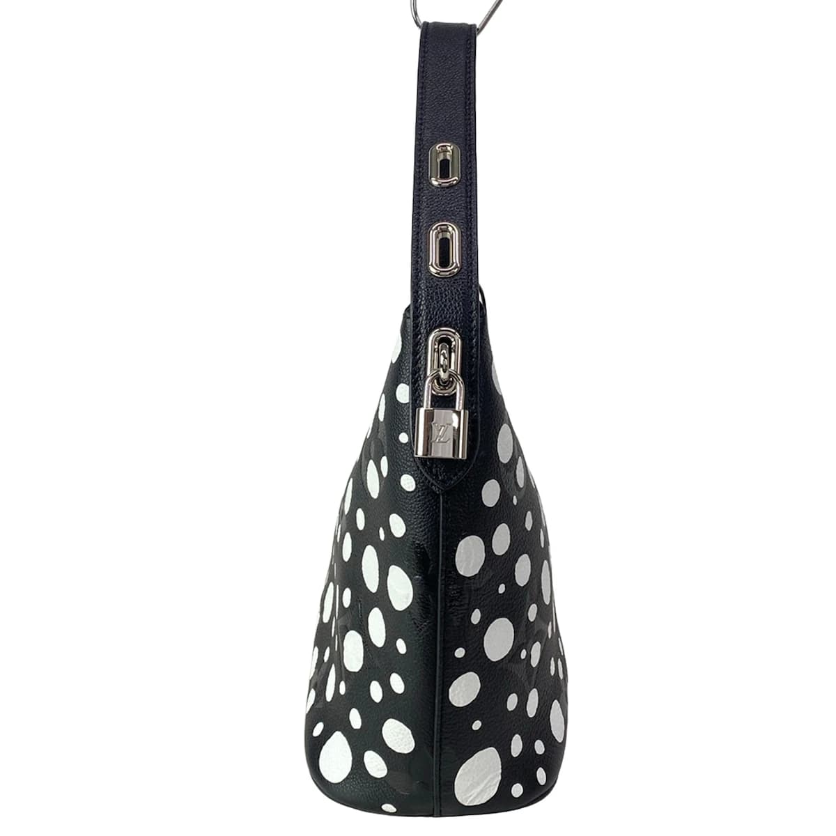 Patterned handbag covered in repeating dot motifs with leather trim and a top handle.