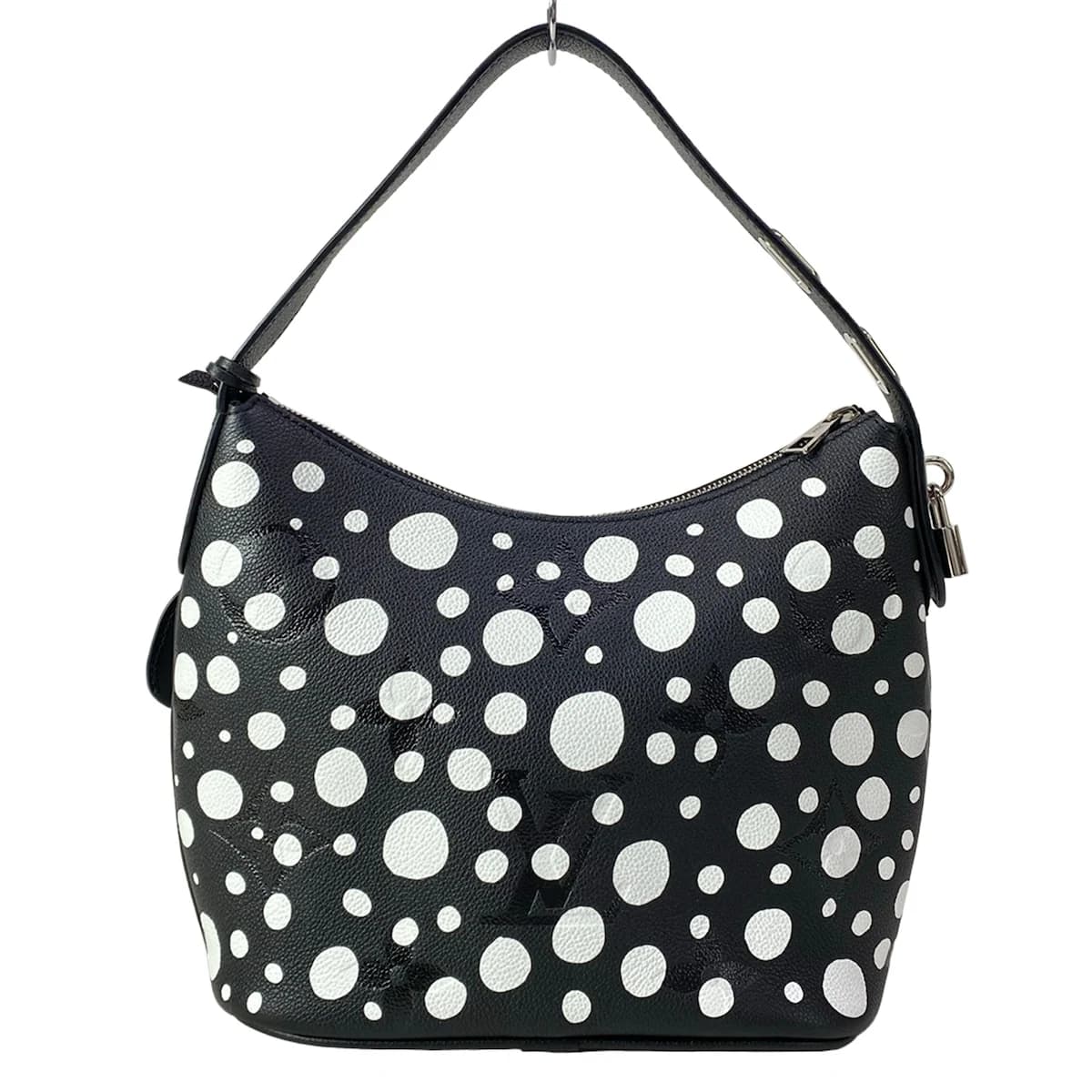 Patterned handbag covered in repeating dot motifs with leather trim and a top handle.